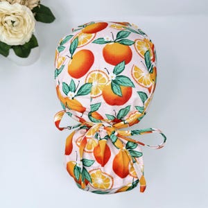 Orange Ponytail scrub cap for women. Fruit Surgical hat with satin lined option by Paradise Caps.
