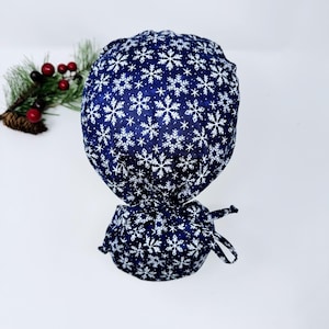 Christmas Ponytail scrub cap for women, Snowflakes on Blue Surgical cap with ponytail with satin lined by Paradise Caps.