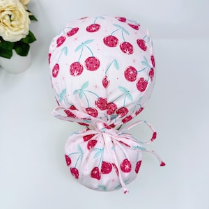 Cherries Ponytail scrub cap with satin lined. Pink surgical cap for women by Paradise Caps.