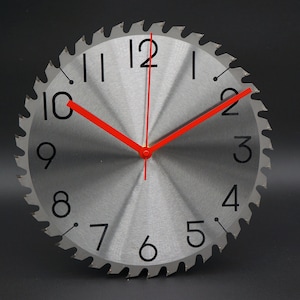 May include: A silver circular clock with black numbers and red hands, designed to look like a saw blade.
