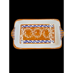 May include: Rectangular ceramic serving dish with orange, white, and blue accents. The dish features a white border, orange center with white floral design, and blue wave pattern. Handles on each end.