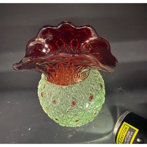 Puede incluir: Una taza de cerámica blanca con un asa negra y el texto "But First, Coffee" en negro, con una fuente de estilo manuscrito. La taza está sobre una superficie blanca.