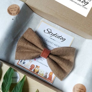 Könnte beinhalten: Ein braunes Fliege für einen Hund, verpackt in einer Schachtel mit weißer Seidenpapierauskleidung. Die Schachtel hat einen Aufkleber mit der Aufschrift "Handgefertigt mit Liebe".