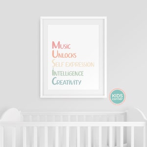 Op de afbeelding: Een witte ingelijste print met de tekst "Music unlocks self expression intelligence creativity" in een regenboogkleurige gradi&euml;nt. De print hangt aan een witte muur boven een wit wiegje.