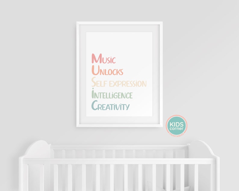 Op de afbeelding: Een witte ingelijste print met de tekst "Music unlocks self expression intelligence creativity" in een regenboogkleurige gradi&euml;nt. De print hangt aan een witte muur boven een wit wiegje.