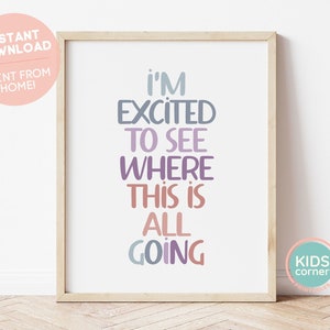 Puede incluir: Una impresión de arte de pared imprimible con el texto "I'm excited to see where this is all going" en un arcoíris de colores. La impresión está enmarcada en un marco de madera claro.