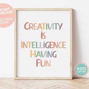 Pode incluir: Uma impressão de arte de parede imprimível com o texto "Creativity is intelligence having fun" em letras coloridas. A impressão é emoldurada em uma moldura de madeira clara e tem um fundo branco.