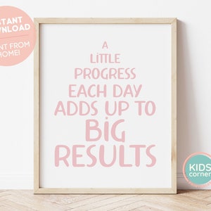 May include: A pink motivational quote print in a wooden frame. The quote reads "A little progress each day adds up to big results".