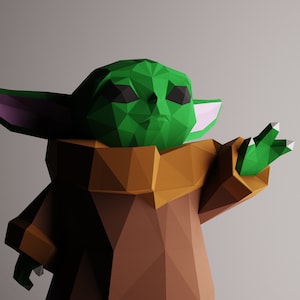 Puede incluir: Una figura de origami de un personaje de la franquicia Star Wars. La figura es de color verde y marrón, con orejas grandes y una mano extendida.