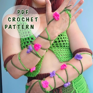 Op de afbeelding: Groen en bruin gehaakt outfit met roze en paarse bloemaccenten. De outfit bestaat uit een top, rok en arm wraps. De afbeelding bevat ook de tekst "PDF CROCHET PATTERN".