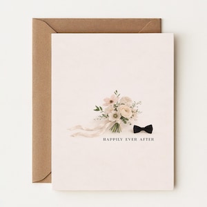 Puede incluir: Tarjeta de boda con un ramo de flores blancas y rosas, una pajarita negra y la frase "Happily Ever After". La tarjeta va acompañada de un sobre marrón.