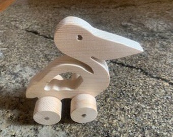 Pelícano de madera sobre ruedas