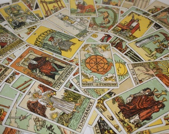 Könnte beinhalten: Ein Satz Tarotkarten, die auf einem Tisch ausgelegt sind. Die Karten sind bunt und zeigen verschiedene Illustrationen, darunter einen Wagen, eine Kaiserin, einen Magier und ein Rad des Schicksals. Die Karten sind in zufälliger Reihenfolge angeordnet.