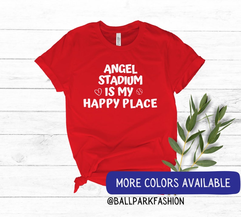 May include: Red t-shirt with white text that reads "Angel Stadium is my happy place" with a heart and baseball graphic.  More colors available @ballparkfashion
