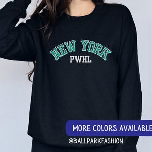 May include: Black sweatshirt with a green and white "NEW YORK PWHL" graphic.