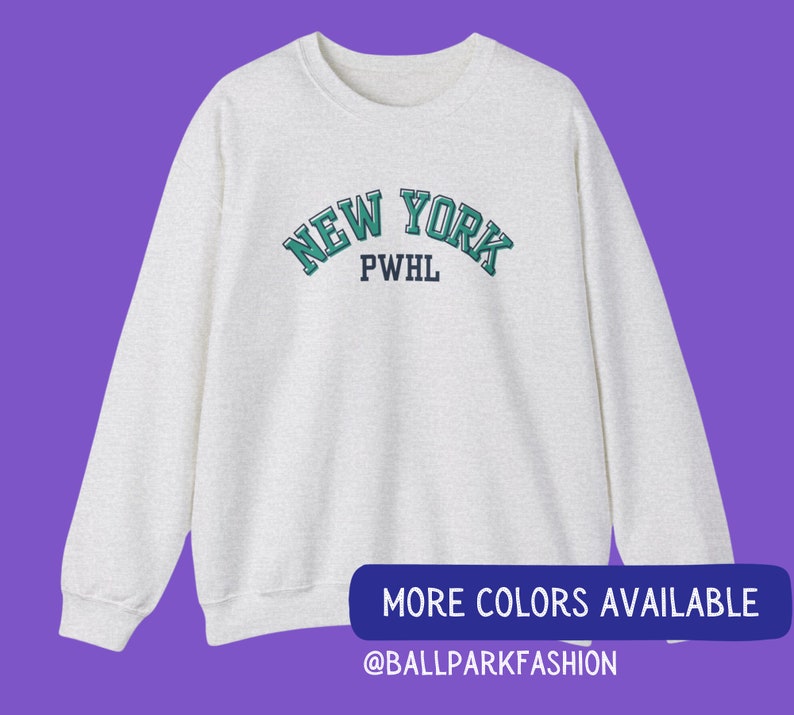 May include: A heather grey sweatshirt with a green and white "NEW YORK" graphic with the text "PWHL" underneath. The sweatshirt is a long-sleeved crew neck style.