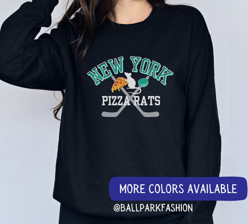 May include: Black sweatshirt with a green and white graphic design that says "New York Pizza Rats" with a rat holding a slice of pizza and a hockey puck. The graphic also includes two crossed hockey sticks.