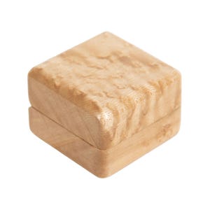 May include: A square wooden box with a hinged lid, crafted from light-coloured wood. The natural grain pattern is visible on the box, which is suitable for jewellery or small items.
