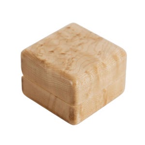 May include: A square wooden box with a lid, crafted from light-coloured wood. The natural grain pattern is visible on the box's surface. The box is closed, suggesting it's empty. Likely used for storing jewellery or small items.