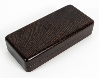 May include: A rectangular wooden box with a dark brown finish and a prominent, natural wood grain pattern. The box features a smooth, polished surface and a clean, simple design with a lid that sits flush against the base of the container.