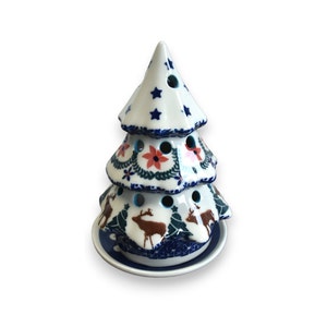 Könnte beinhalten: Ein weißer Keramik-Weihnachtsbaum mit blauen und roten Blumendesigns, Rentieren und Sternen. Der Baum hat drei Ebenen und eine Basis.