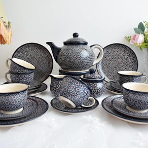 May include: A blue and white patterned tea set with a teapot, creamer, sugar bowl, and four cups and saucers.