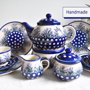 Könnte beinhalten: Ein blaues und weißes Keramik-Tee-Set mit floralem Design. Das Set beinhaltet eine Teekanne, eine Milchkännchen, eine Zuckerdose, zwei Teetassen und zwei Untertassen. Der Text "Handmade" ist im Bild sichtbar.