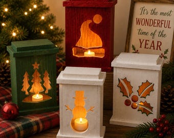 May include: Four rectangular wooden lanterns with cutouts illuminated by tea lights. One green lantern features pine trees, one red lantern shows a Santa hat, and two white lanterns display a snowman and holly leaves. A sign reads It's the most WONDERFUL time of the YEAR.
