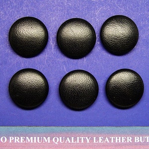 May include: Six black leather buttons with a textured surface.  The buttons are arranged in two rows of three.  The buttons are on a purple background.  The text "SOGNO PREMIUM QUALITY LEATHER BUTTONS" is printed on a pink and blue background below the buttons.