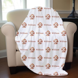 May include: White fleece blanket with a repeating pattern of brown cartoon monkeys wearing bow ties. The name "William" is printed in brown text on each monkey.
