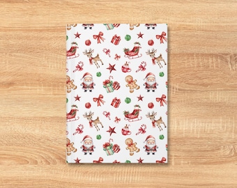 May include: A white notebook with a festive Christmas pattern. The design includes Santa Claus, reindeer, sleighs, gifts, candy canes, stars, bows, and gingerbread men in red, green, and brown. The notebook is rectangular and sits on a wooden surface.