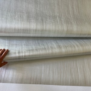 a hand is reaching for a piece of fabric