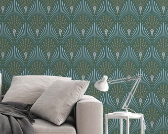 May include: A light beige sofa with a gray throw blanket sits in front of a wall with a green and blue geometric pattern. A white side table with a lamp sits next to the sofa.