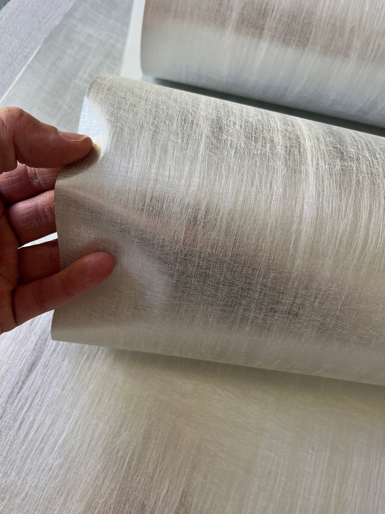 a hand is holding a piece of white fabric