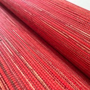 May include: Close-up of red and natural woven wallpaper with a textured, striped pattern.