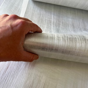 a person is holding a curtain with their hand