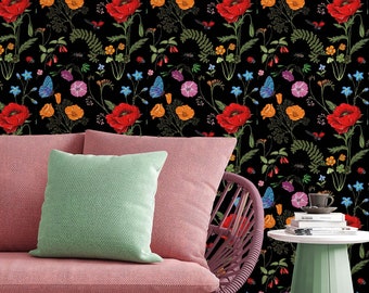 May include: A pink wicker chair with a green cushion sits in front of a black background with a floral pattern. The pattern features red poppies, orange flowers, and blue butterflies.