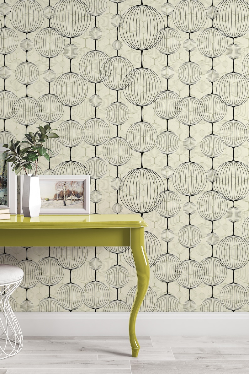 以下が含まれることがあります： テーブルは黄色で、上に白い額縁の写真が置かれています。テーブルの後ろの壁には、黒と白の円形の模様があります。