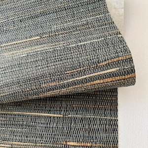 Può includere: Primo piano di un rivestimento murale intrecciato con un aspetto naturale e testurizzato. Il materiale è una miscela di fibre nere e marroni, creando un sottile motivo a righe.