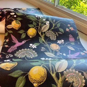 May include: Black wallpaper with a repeating pattern of lemons, hummingbirds, and floral designs. The wallpaper has a textured, linen-like finish.