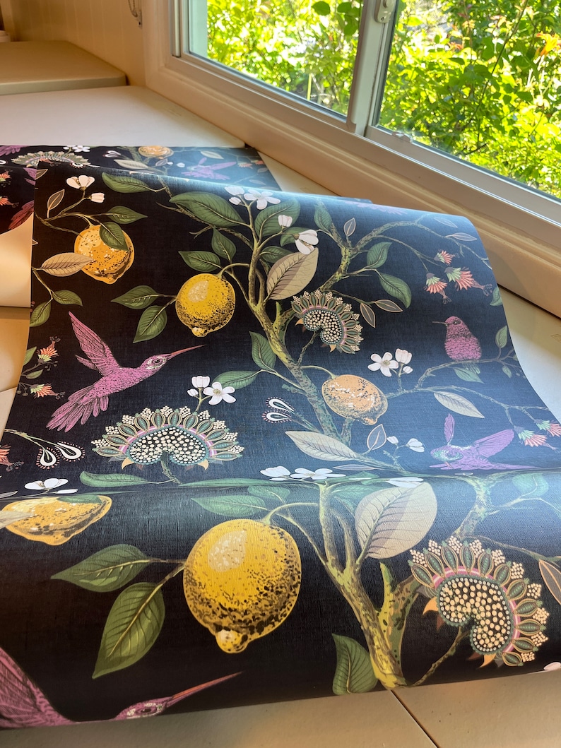 May include: Black wallpaper with a repeating pattern of lemons, hummingbirds, and floral designs. The wallpaper has a textured, linen-like finish.