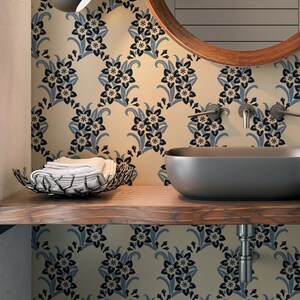 May include: A bathroom vanity with a dark wood countertop and a white ceramic sink. The wall behind the sink is covered in a floral wallpaper with a blue and white pattern. A round mirror with a wooden frame hangs above the sink.