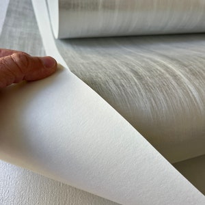 a person holding a roll of white paper