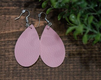 May include: A pair of pink leather teardrop earrings with silver hooks.