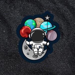 Weltraum Sticker - Astronaut sitzt auf dem Mond und hält Stern- und Planetenballons