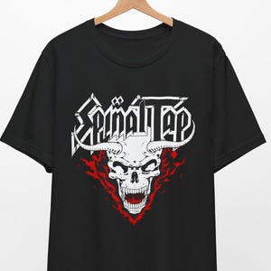 May include: Black t-shirt featuring a white skull with horns and flames behind it. The text "Spinal Tap" is above the skull.