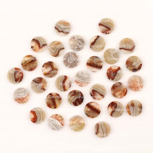 Puede incluir: Una colección de 25 cabujones redondos de ágata en varios tonos de marrón, blanco y beige. Los cabujones tienen un patrón natural y orgánico y son perfectos para la elaboración de joyas o manualidades.