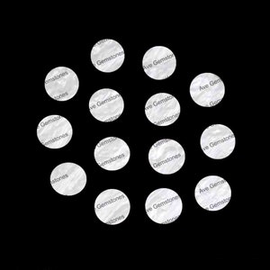 May include: A collection of white round stickers with the text "Ave Gemstone" and "Gemstones" repeated on each sticker.