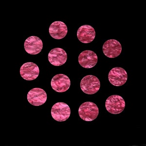 May include: A collection of 13 pink and white round stickers with the text "Ave Gemstones" on them.