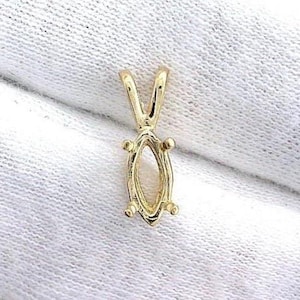 Op de afbeelding: Een goudkleurige hangerzetting met een marquise-vormig middenstuk. De zetting heeft een V-vormige beugel en kleine pootjes rond de ovale opening, ontworpen om een edelsteen vast te houden. De hanger wordt getoond op een witte stof.